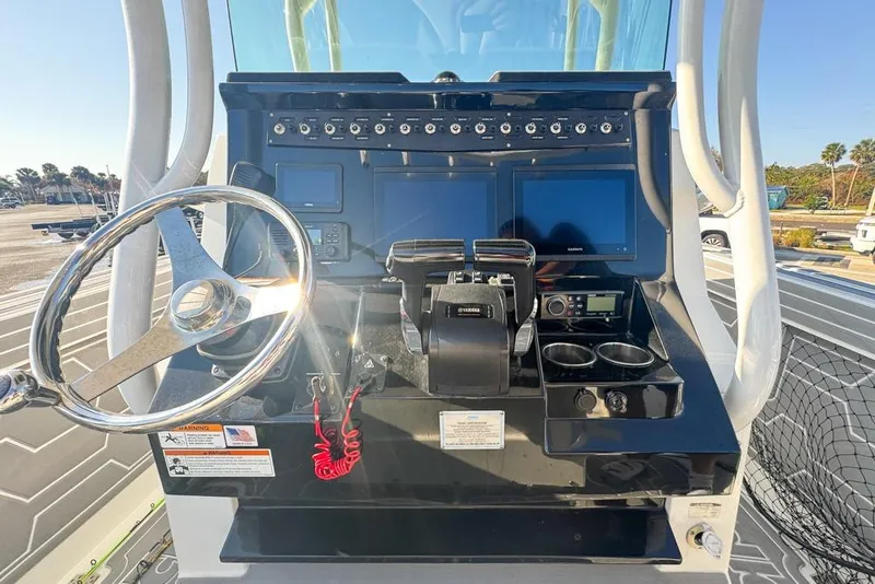 Slide: The Image of 2021 Wellcraft 262 Fisherman boat dashboard with steering wheel and electronic controls. - 55
