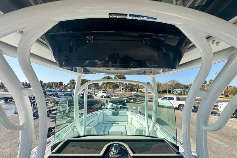 Slide: The Image of 2021 Wellcraft 262 Fisherman boat interior with T-top and windshield, parked outdoors. - 58