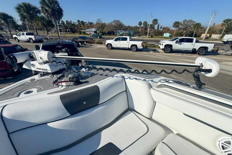 Slide: The Image of 2021 Wellcraft 262 Fisherman boat with Minn Kota trolling motor, parked near trucks. - 65