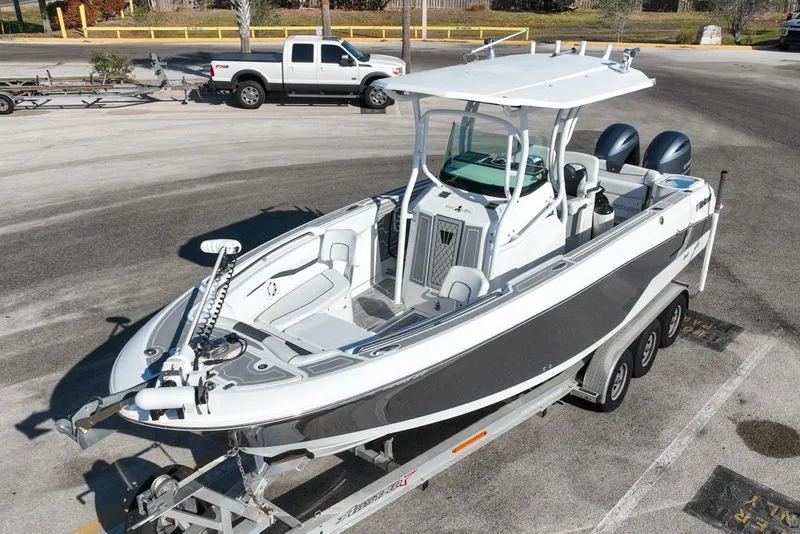 Slide: The Image of 2021 Wellcraft 262 Fisherman boat on trailer in parking lot, featuring dual engines. - 7