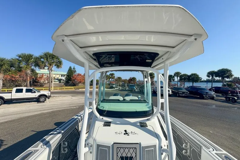 Slide: The Image of 2021 Wellcraft 262 Fisherman boat with T-top, parked near palm trees and waterfront. - 79