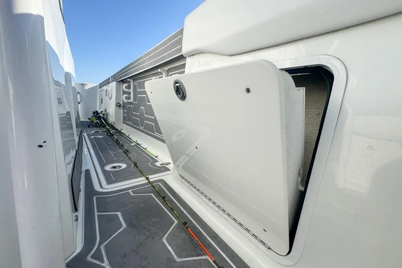 Slide: The Image of 2021 Wellcraft 262 Fisherman boat interior with open storage compartment and fishing rods. - 87