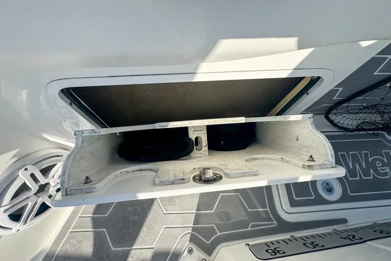 Slide: The Image of 2021 Wellcraft 262 Fisherman boat storage compartment with open hatch and visible interior. - 90