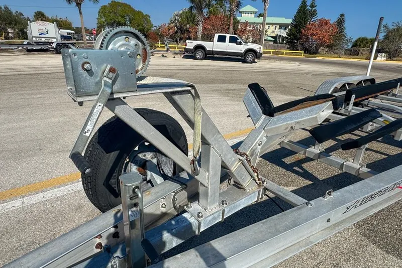 Slide: The Image of Boat trailer for 2021 Wellcraft 262 Fisherman, parked in sunny lot with palm trees. - 98
