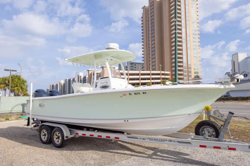 Slide: The Image of 2016 Sea Hunt Gamefish 25 boat on trailer, urban background, clear sky. - 10