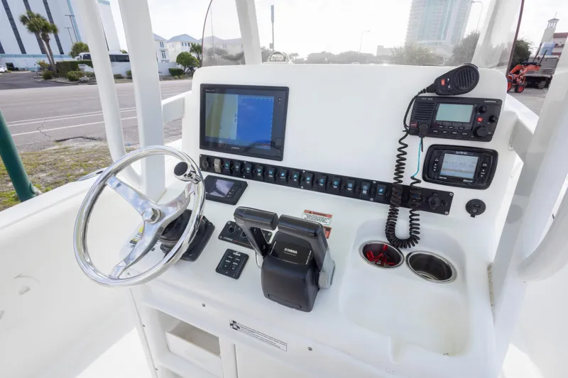 Slide: The Image of 2016 Sea Hunt Gamefish 25 helm with steering wheel, navigation, and communication equipment. - 16