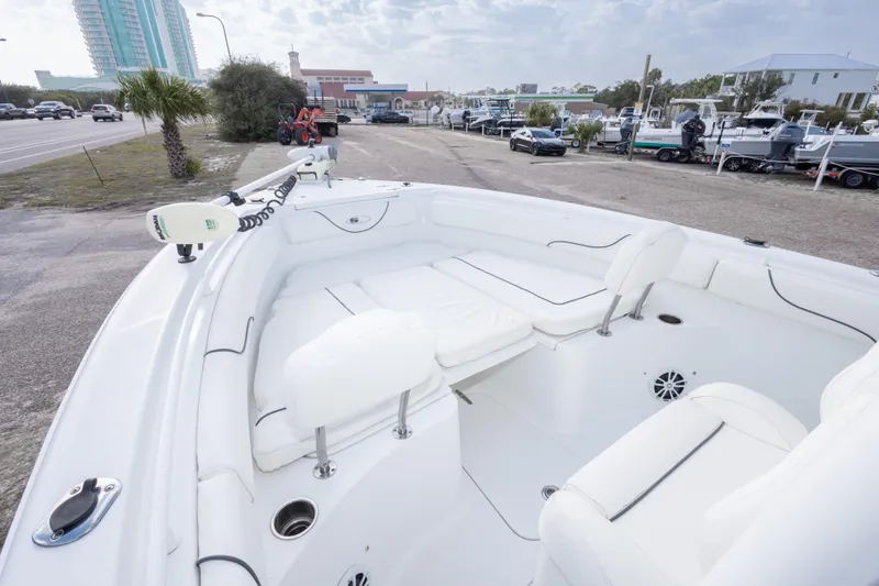 Slide: The Image of 2016 Sea Hunt Gamefish 25 boat with spacious seating, parked near a coastal road. - 20
