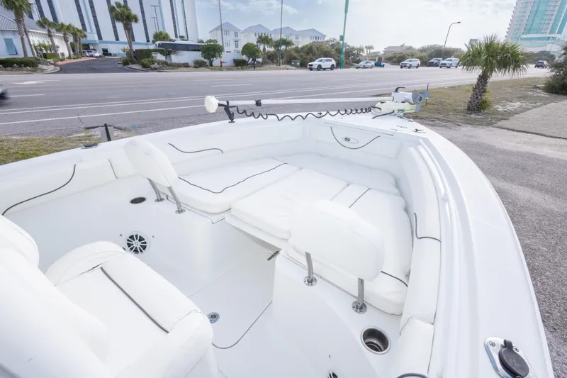 Slide: The Image of 2016 Sea Hunt Gamefish 25 boat interior with white seating, parked near a road. - 21
