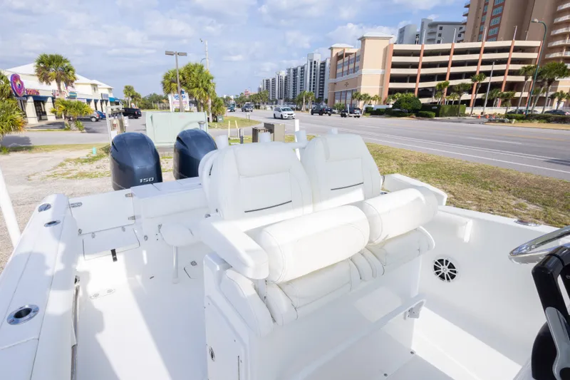 Slide: The Image of 2016 Sea Hunt Gamefish 25 boat with dual engines, parked near a coastal road. - 26