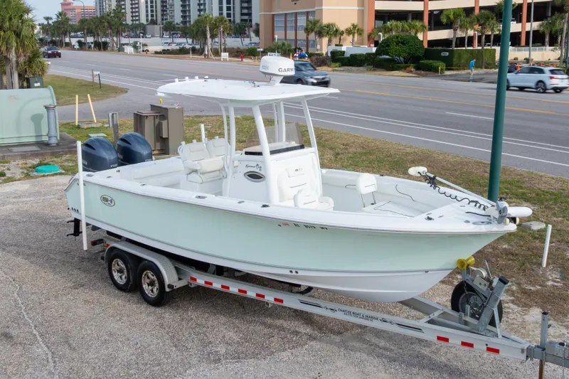 Slide: The Image of 2016 Sea Hunt Gamefish 25 boat on trailer, parked near a road. - 27