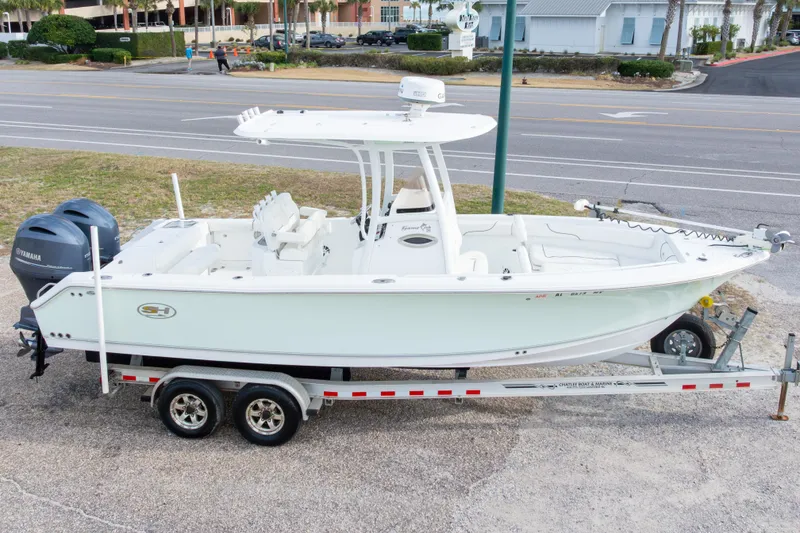 Slide: The Image of 2016 Sea Hunt Gamefish 25 boat on trailer, parked near a road. - 28