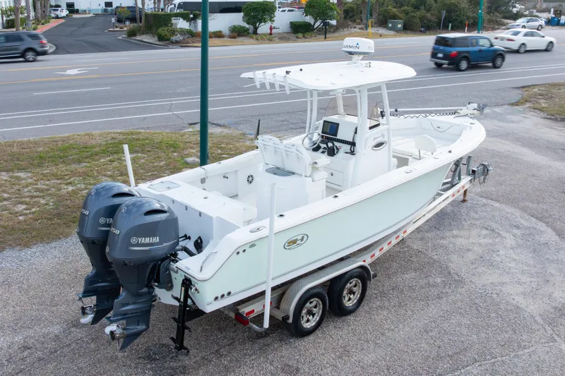 Slide: The Image of 2016 Sea Hunt Gamefish 25 boat on trailer with dual Yamaha engines, parked near road. - 29