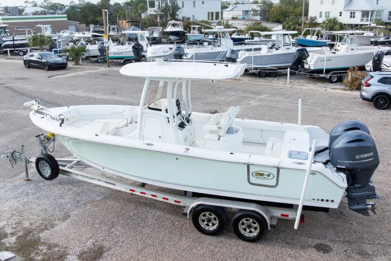 Slide: The Image of 2016 Sea Hunt Gamefish 25 boat on trailer, parked in a marina with other boats. - 32