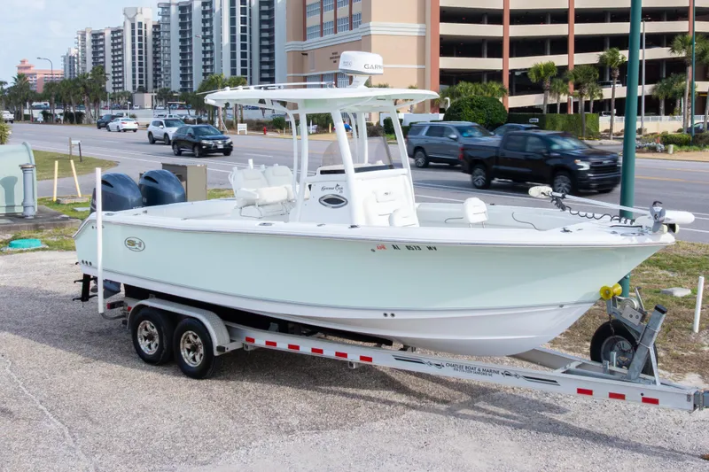 Slide: The Image of 2016 Sea Hunt Gamefish 25 boat on trailer, parked near a busy street. - 36