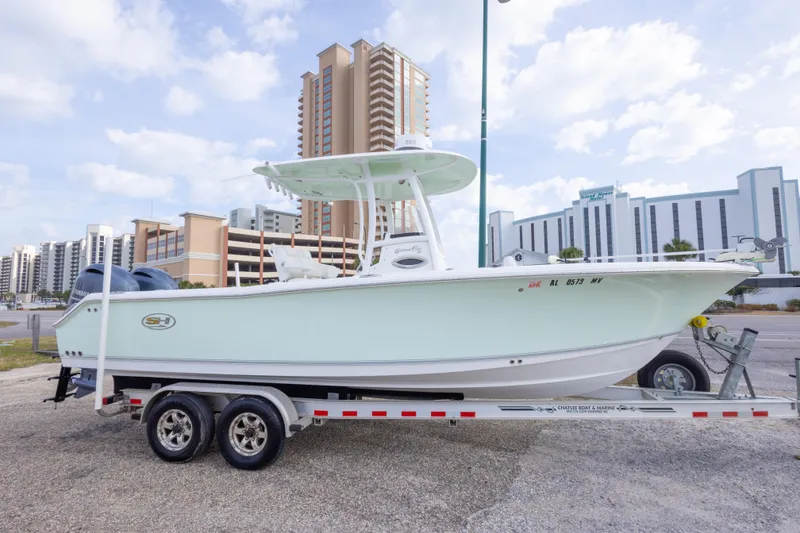 Slide: The Image of 2016 Sea Hunt Gamefish 25 boat on trailer, urban background, clear sky. - 4