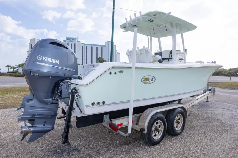 Slide: The Image of 2016 Sea Hunt Gamefish 25 boat on trailer with Yamaha engine, parked outdoors. - 5