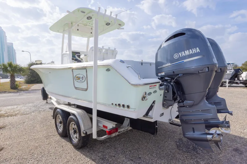 Slide: The Image of 2016 Sea Hunt Gamefish 25 boat with dual Yamaha engines on a trailer. - 7