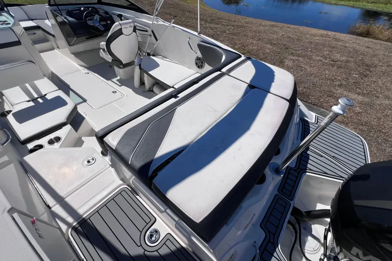 Slide: The Image of 2015 Sea Ray 21 SPX OB boat interior with seating and steering wheel, near water. - 14