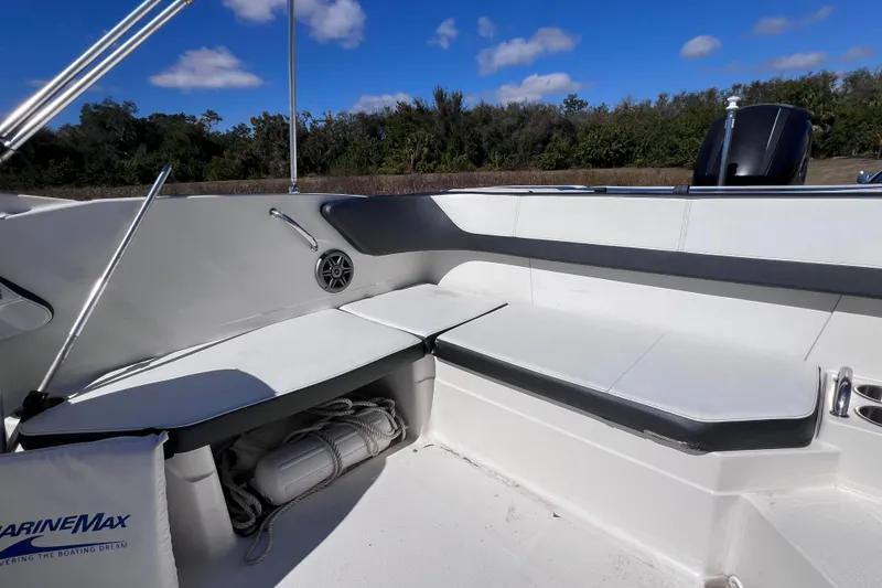 Slide: The Image of 2015 Sea Ray 21 SPX OB boat interior with seating and storage under blue sky. - 24
