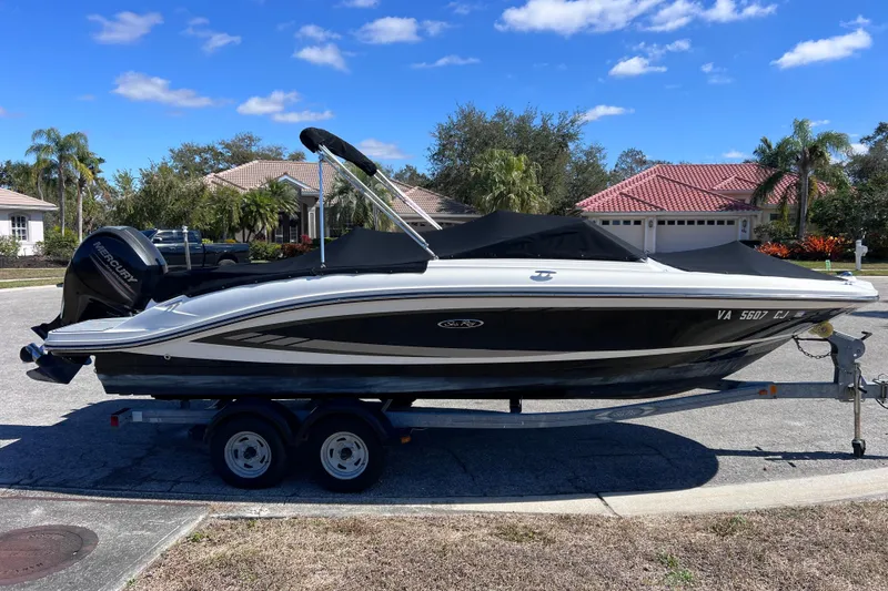 Slide: The Image of 2015 Sea Ray 21 SPX OB boat on trailer, parked in suburban neighborhood. - 3