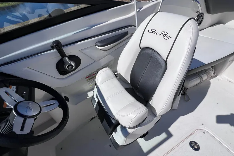 Slide: The Image of 2015 Sea Ray 21 SPX OB boat interior with steering wheel and branded seat. - 30