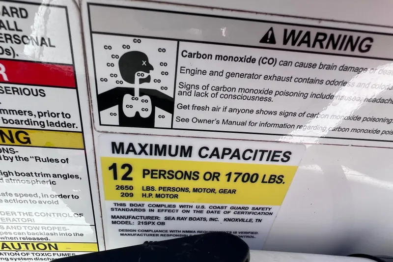 Slide: The Image of Warning label on 2015 Sea Ray 21 SPX OB boat, detailing carbon monoxide risks and maximum capacity. - 43
