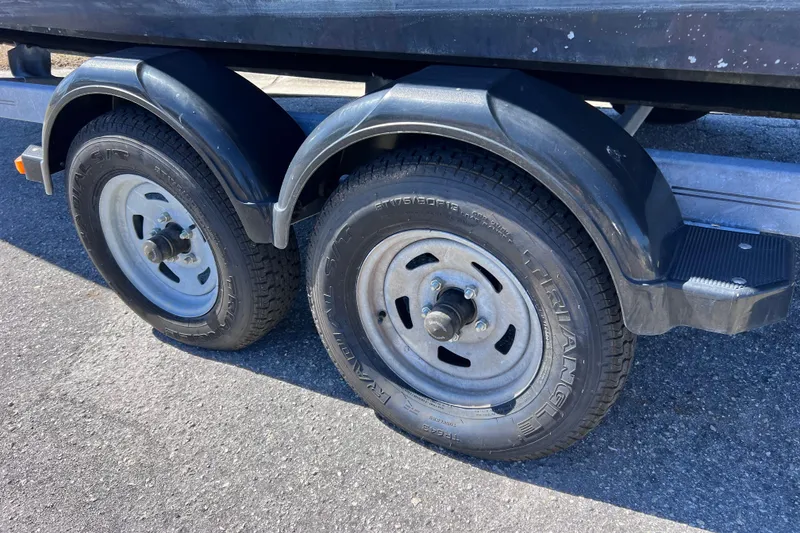 Slide: The Image of Trailer wheels for 2015 Sea Ray 21 SPX OB boat on asphalt surface. - 8