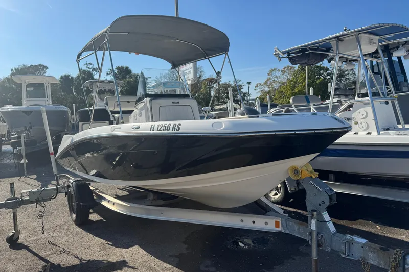 Slide: The Image of 2018 Yamaha Boats 190 FSH Deluxe on trailer, parked in a marina. - 10