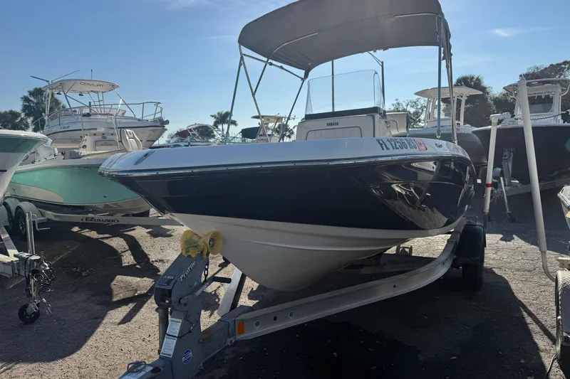 Slide: The Image of 2018 Yamaha Boats 190 FSH Deluxe on trailer, parked among other boats. - 12