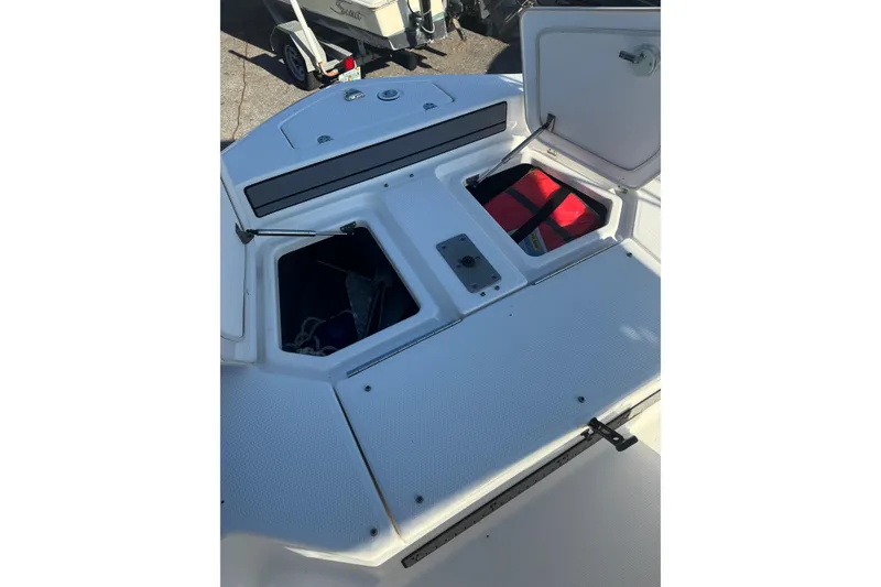 Slide: The Image of 2018 Yamaha Boats 190 FSH Deluxe storage compartments open, revealing interior contents. - 19