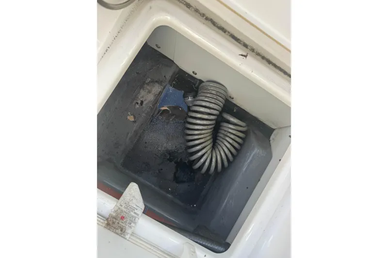 Slide: The Image of Storage compartment of a 2018 Yamaha Boats 190 FSH Deluxe with coiled hose. - 29