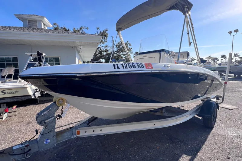 Slide: The Image of 2018 Yamaha Boats 190 FSH Deluxe on trailer, parked outdoors under clear sky. - 6