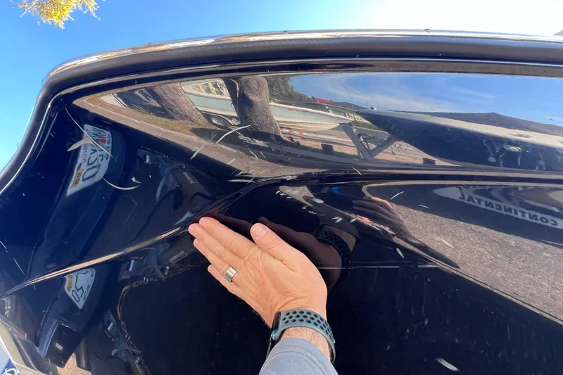 Slide: The Image of Hand inspecting scratches on a 2018 Yamaha Boats 190 FSH Deluxe hull. - 8