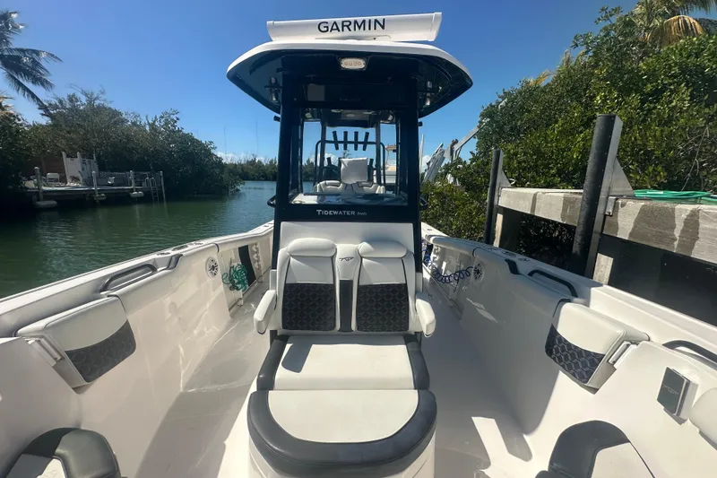 Slide: The Image of 2021 Tidewater 292 CC Adventure boat docked near waterfront home. - 10