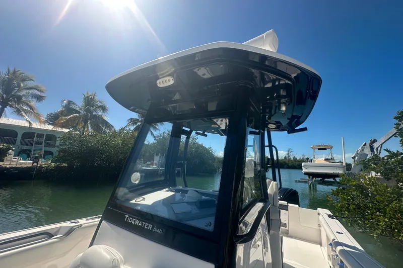 Slide: The Image of 2021 Tidewater 292 CC Adventure boat docked on a sunny day. - 2