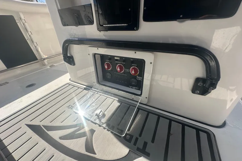 Slide: The Image of Boat trailer parked on gravel driveway, surrounded by tropical greenery and residential buildings. - 26