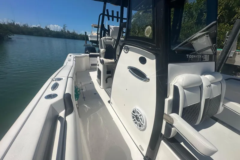 Slide: The Image of 2021 Tidewater 292 CC Adventure boat interior with cushioned seating and speakers. - 4