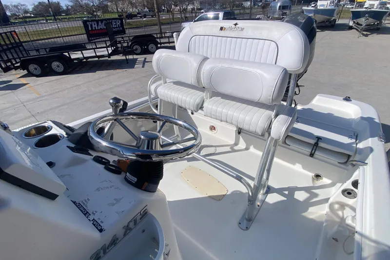 Slide: The Image of 2014 NauticStar 214 XTS Shallow Bay boat interior with steering wheel and seating. - 13