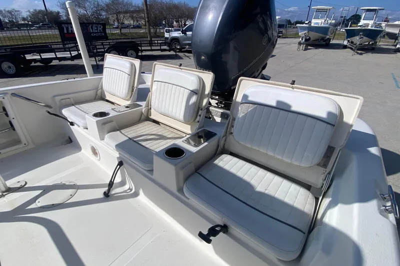 Slide: The Image of 2014 NauticStar 214 XTS Shallow Bay boat with three white cushioned seats and cup holders. - 14