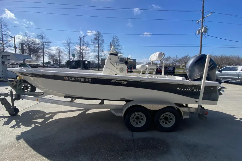 Slide: The Image of 2014 NauticStar 214 XTS Shallow Bay boat on trailer, parked outdoors. - 7
