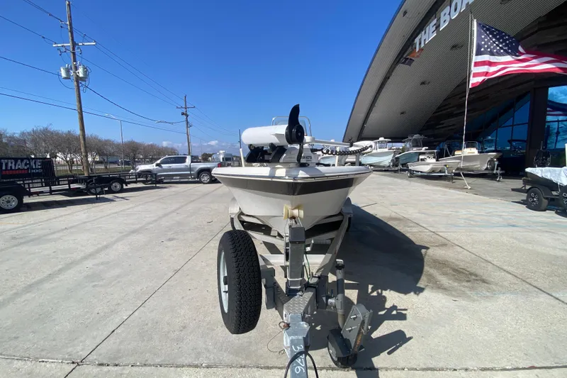 Slide: The Image of 2014 NauticStar 214 XTS Shallow Bay boat on trailer at dealership, American flag visible. - 9