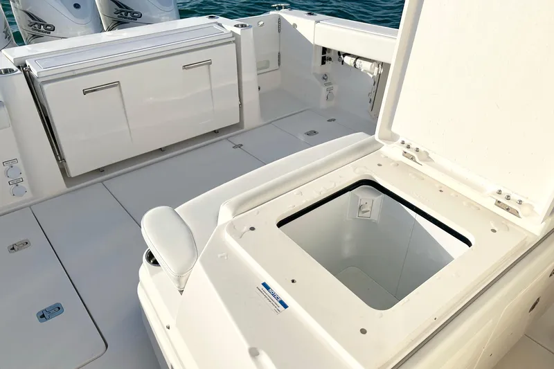 Slide: The Image of 2023 Pursuit S 378 Sport boat deck with open storage compartment and Yamaha XTO engines. - 22