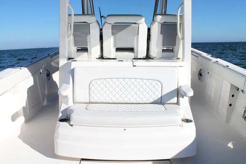 Slide: The Image of 2023 Pursuit S 378 Sport boat interior with white seating and ocean backdrop. - 25