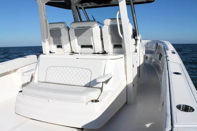 Slide: The Image of 2023 Pursuit S 378 Sport boat interior with white seating and ocean view. - 28