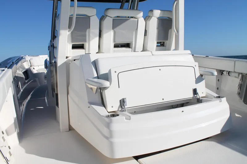 Slide: The Image of 2023 Pursuit S 378 Sport boat interior with seating and storage, under clear blue sky. - 29