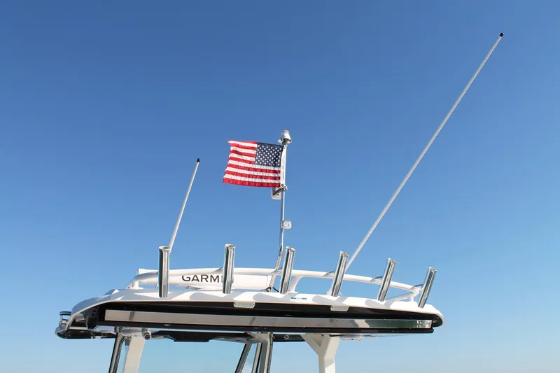 Slide: The Image of 2023 Pursuit S 378 Sport boat with American flag against clear blue sky. - 33