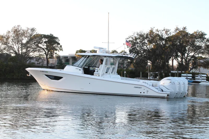 Slide: The Image of 2023 Pursuit S 378 Sport boat cruising on a calm river with trees in the background. - 4