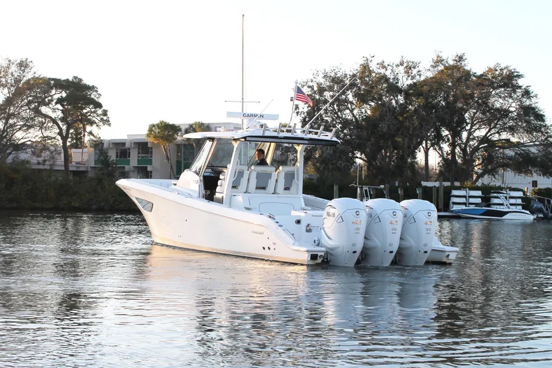 Slide: The Image of 2023 Pursuit S 378 Sport boat on calm water with trees in the background. - 5
