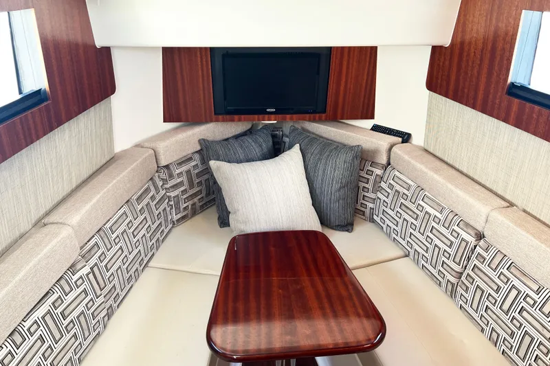 Slide: The Image of 2023 Pursuit S 378 Sport cabin with plush seating and elegant wood table. - 60