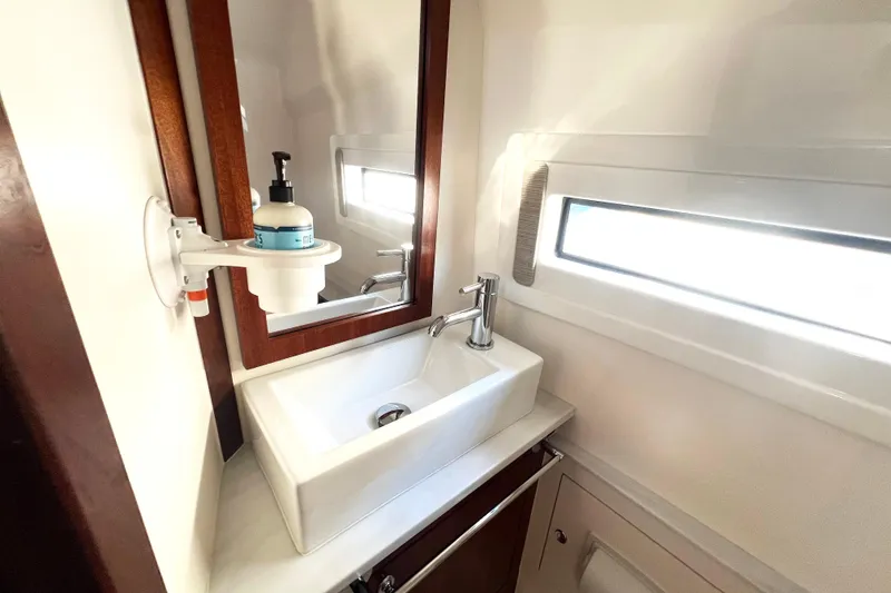 Slide: The Image of 2023 Pursuit S 378 Sport boat bathroom with modern sink and window. - 64
